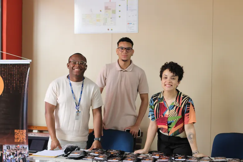 Três pessoas em um dos estandes do evento