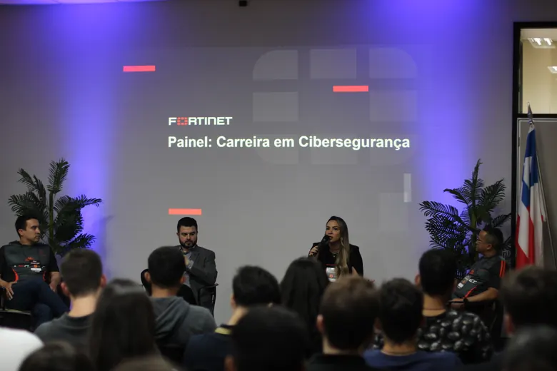 Painel da Fortinet sobre carreira em cibersegurança, com a plateia no auditório