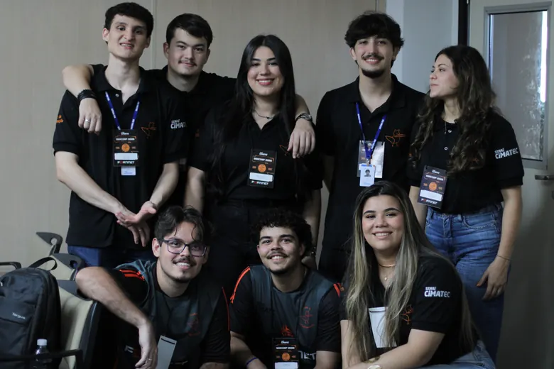 Grupo de estudantes com crachá posando juntos