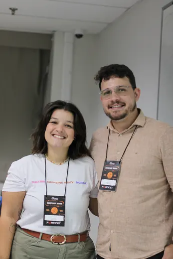 Duas pessoas com crachá posando para a foto