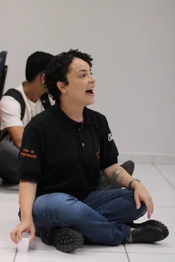 Participante sentada no chão, sorrindo