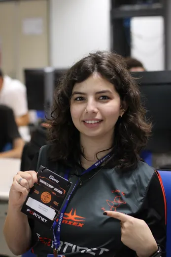 Participante mostrando o crachá do evento