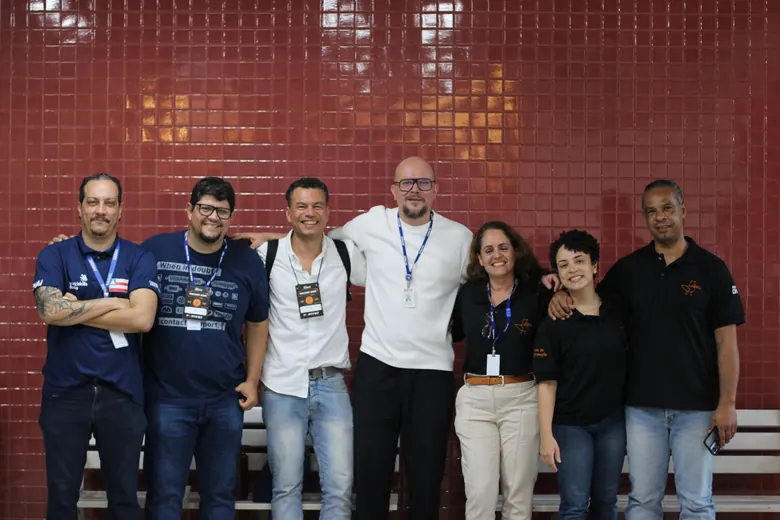 Grupo posando diante de uma parede vermelha